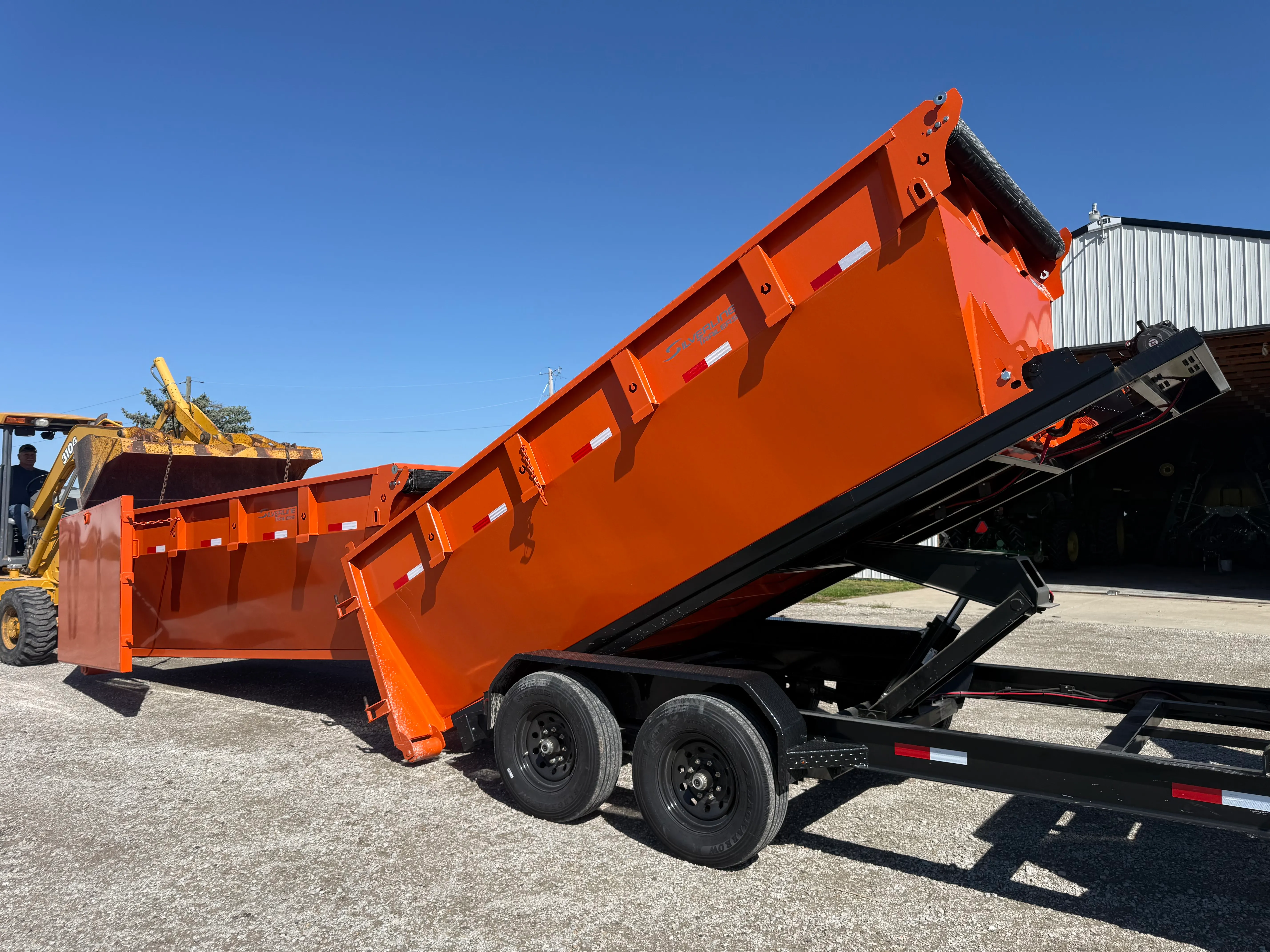 Dump trailer lifting its bed to dump waste